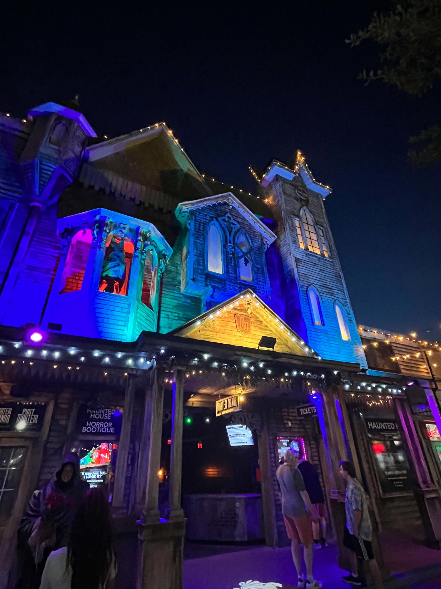 mortem manor at night with blue and purple lights